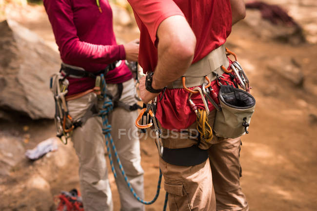 Mid section of couple adjusting their carabiner — Stock Photo