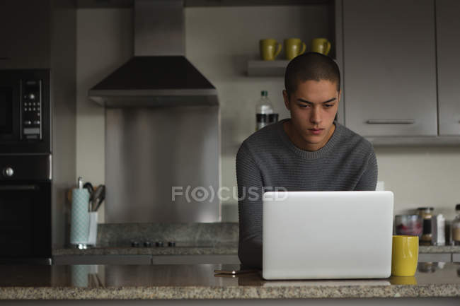 Jovem usando laptop em casa — Fotografia de Stock