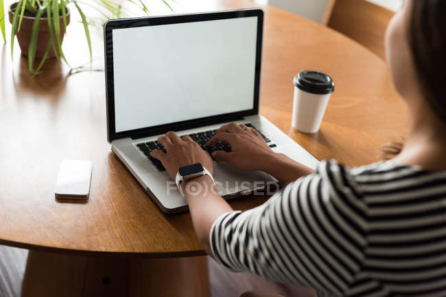 Женщина-руководитель с ноутбуком на столе в офисе — стоковое фото