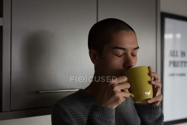 Молодой человек пьет кофе дома — стоковое фото