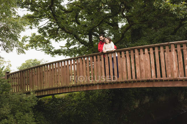 Прихильна пара стоїть на пішохідному мосту — стокове фото
