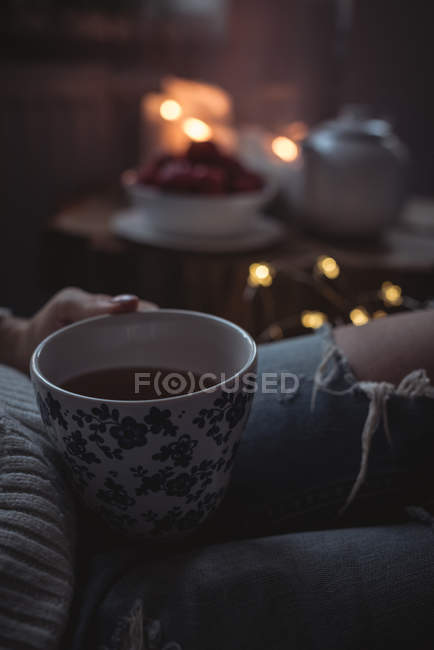 Cropped image of woman holding a cup of tea at home — Stock Photo