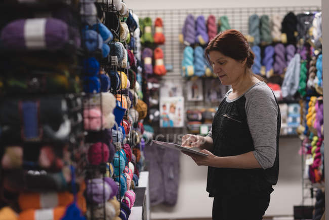 Женщина с цифровым планшетом в швейной мастерской в портной — стоковое фото