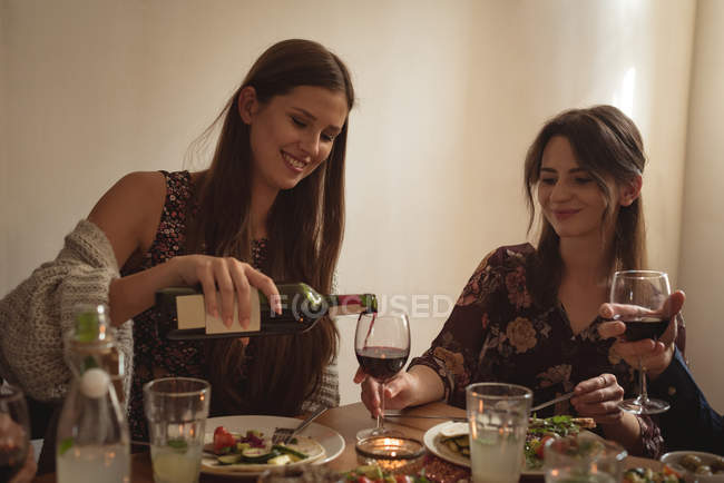 Glückliche Freundin beim Essen am Tisch — Stockfoto