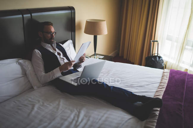 Businessman reading a document in hotel room — Stock Photo