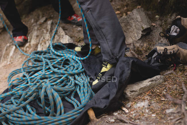 Sección baja de excursionistas preparándose para escalar en roca - foto de stock