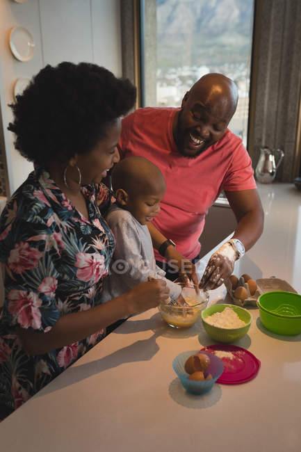 Famille avec fils préparant la nourriture dans la cuisine à la maison . — Photo de stock