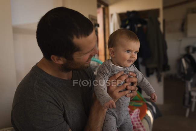 Happy father holding baby boy at home. — Stock Photo