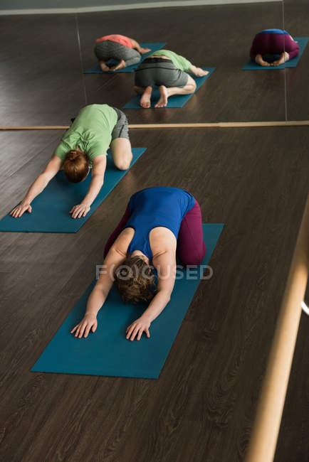 Group of fit athletes practicing yoga in fitness studio. — Stock Photo