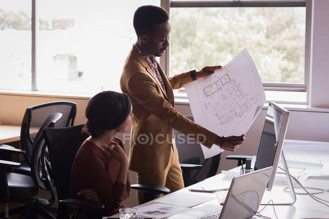 Office executive discussing on blueprint at desk in the office — Stock Photo