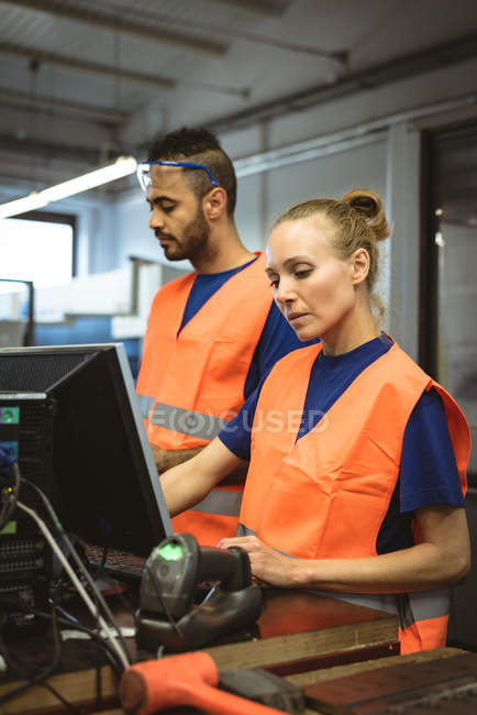 Two workers working on the computer in factory — Stock Photo