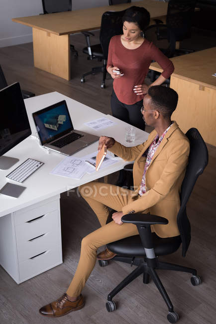 Bürokollegen diskutieren am Laptop am Schreibtisch im Büro — Stockfoto