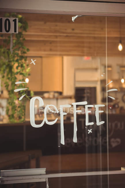 Слово кава написано на вхідних дверях кафе — стокове фото