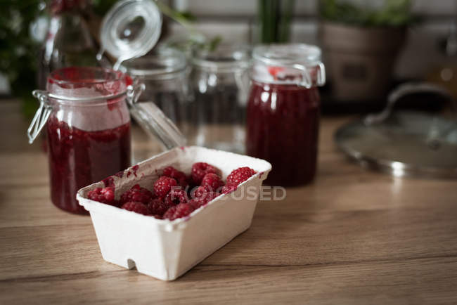 Raspberry bowl with jam on wooden table at home — Stock Photo