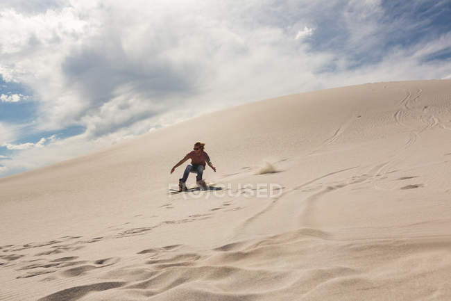 Frau beim Sandboarding auf Sanddüne in der Wüste — Stockfoto