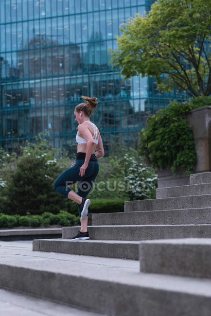 Jovem mulher esportiva correndo na rua — Fotografia de Stock