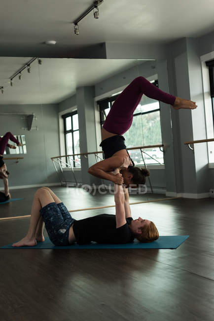 Підійде чоловік і жінка, які практикують акройогу в фітнес-студії . — стокове фото