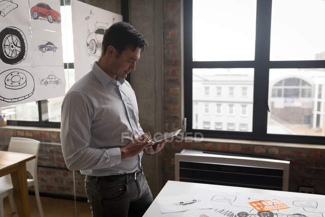 Empresário atento usando tablet digital no escritório . — Fotografia de Stock