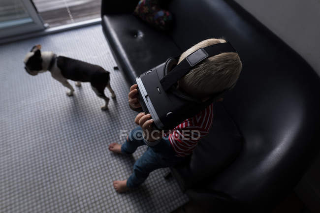 Boy using virtual reality headset in living room at home, high angle view. — Stock Photo
