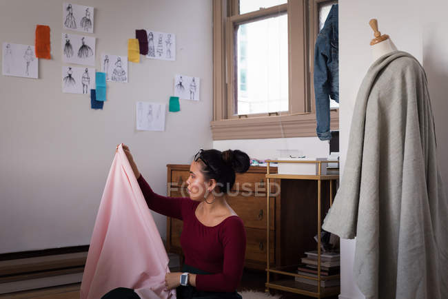 Fashion designer checking fabric in studio. — Stock Photo