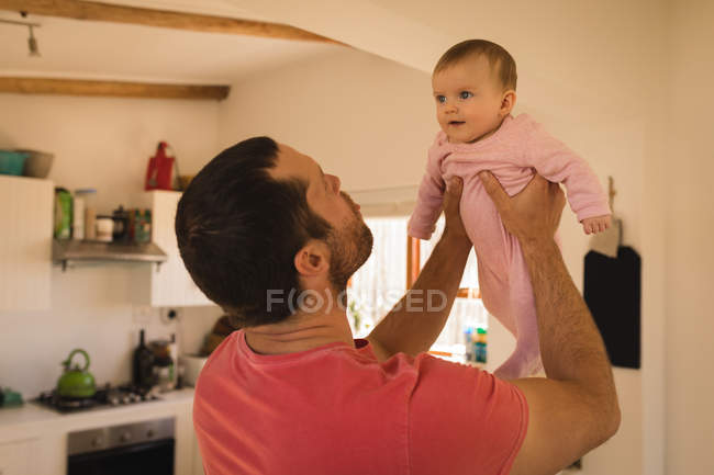 Padre che gioca e solleva il bambino a casa . — Foto stock
