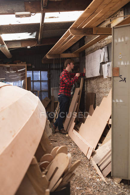 Плотник-мужчина смотрит на карту в мастерской — стоковое фото
