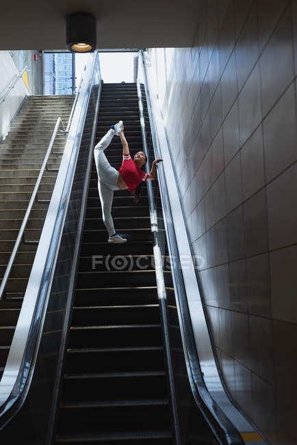 Ballerina di strada che balla sulla scala mobile alla stazione ferroviaria — Foto stock