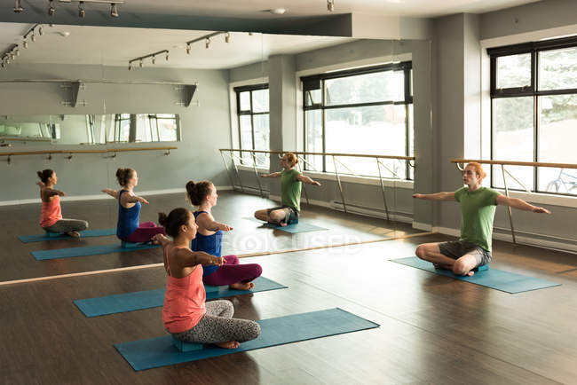 Trainerin unterstützt Frauen beim Yoga im Fitnessstudio. — Stockfoto