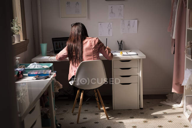 Rear view of fashion designer working in design studio. — Stock Photo