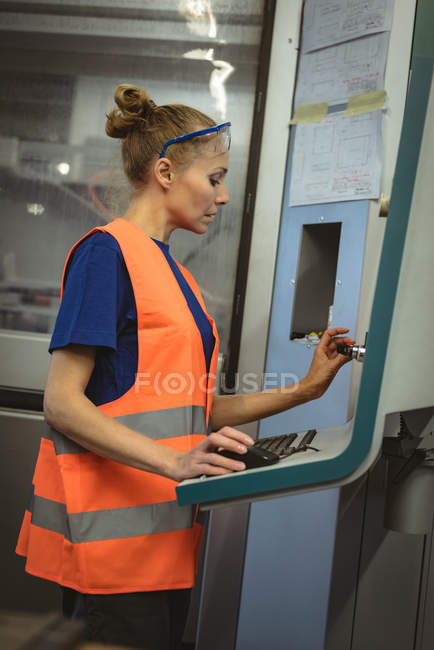 Arbeiterin bedient Maschine in Fabrik — Stockfoto
