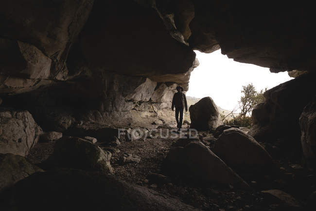 Randonneur entrant dans la grotte le jour — Photo de stock