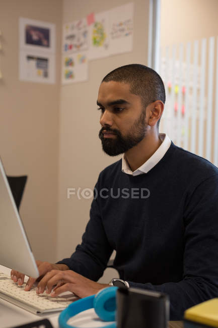 Esecutivo maschile che lavora al computer alla scrivania in ufficio — Foto stock