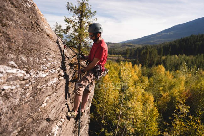 Determined rock climber climbing the rocky mountain — Stock Photo