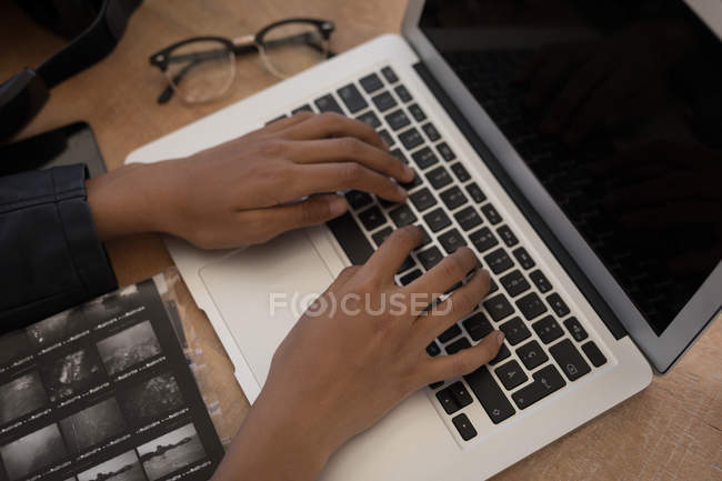 Крупним планом фотограф використовує ноутбук на столі — стокове фото