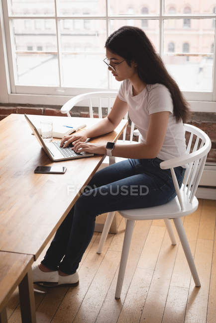 Жіночий керівник використовує ноутбук в офісі — стокове фото
