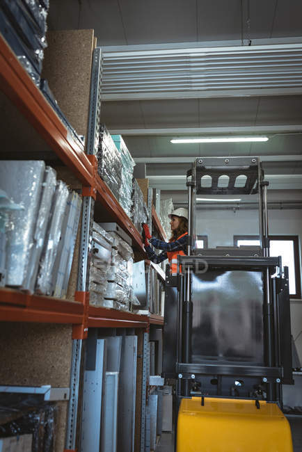 Arbeiterin fährt Gabelstapler in Lagerhalle — Stockfoto