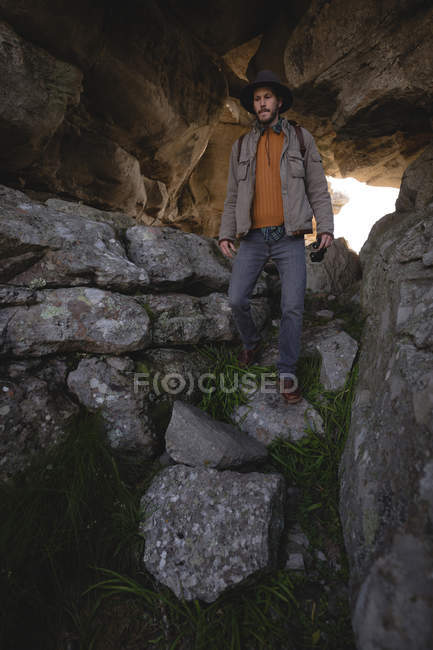 Hiker walking down on rocks in the cave — Stock Photo