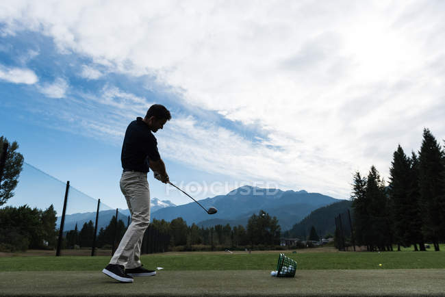 Homme effectuant une oscillation de golf sur le terrain de golf — Photo de stock