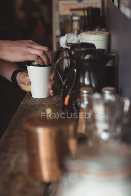 Waiter making coffee at counter in cafe — Stock Photo