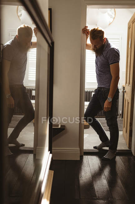 Depressed man lining on wall at home — Stock Photo