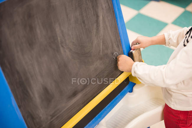 Girl writing on blackboard in book store — Stock Photo
