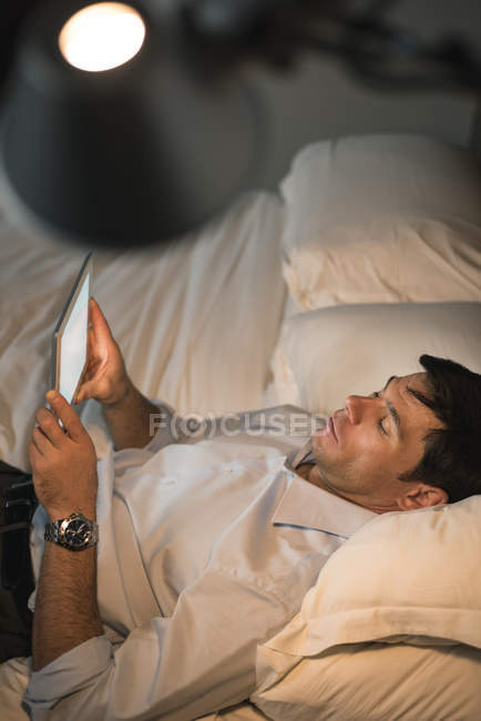 Бізнесмен, використовуючи цифровий планшет у спальні в готелі — стокове фото