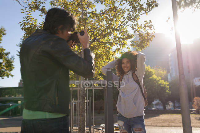 Фотограф фотографирует модель на улице в солнечный день — стоковое фото