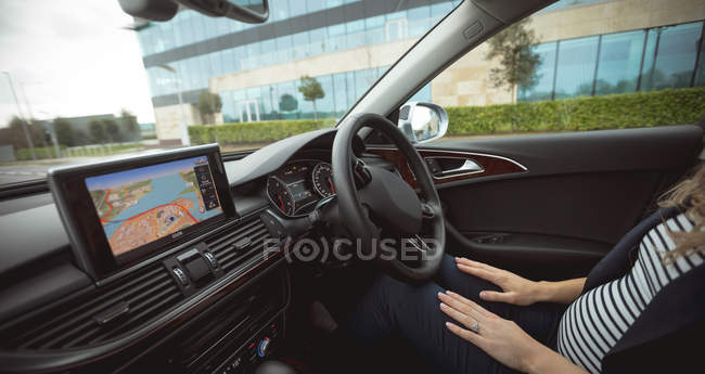 Low section of female executive sitting in the car on street — Stock Photo