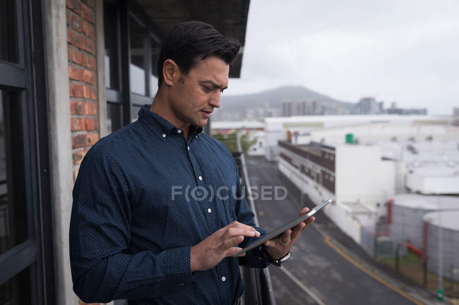 Бізнесмен використовує цифровий планшет на балконі в офісі . — стокове фото