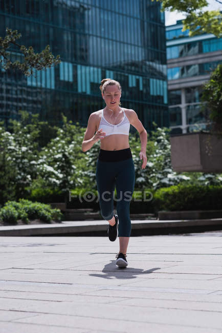 Young sporty woman jogging on street — Stock Photo