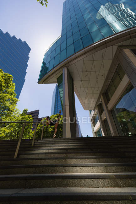 Young female urban dancer dancing on steps in city. — Stock Photo