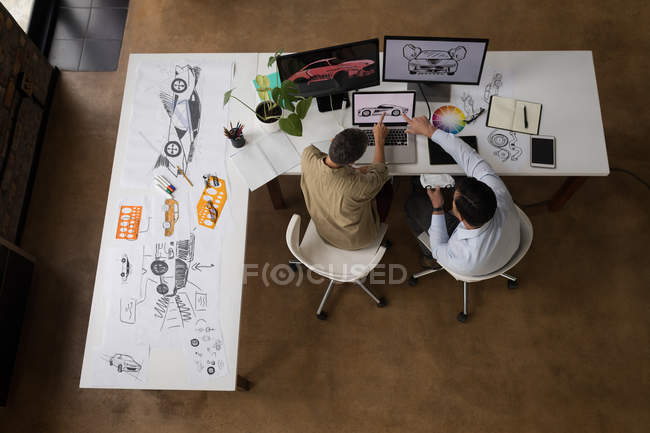 Compañeros de negocios discutiendo sobre portátil en la oficina . - foto de stock