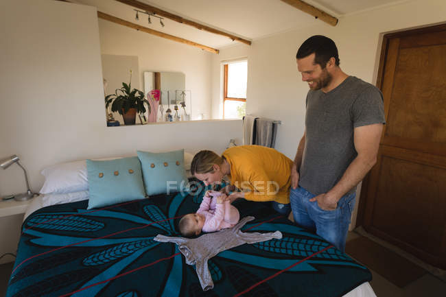 Parents playing with baby boy on bed at home. — Stock Photo