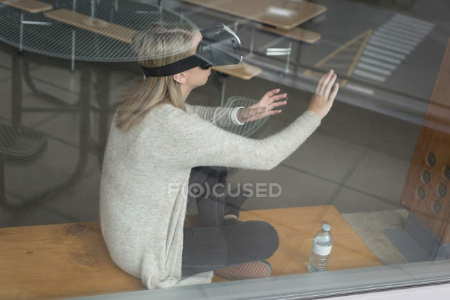 Teenage girl using virtual reality headset in university — Stock Photo
